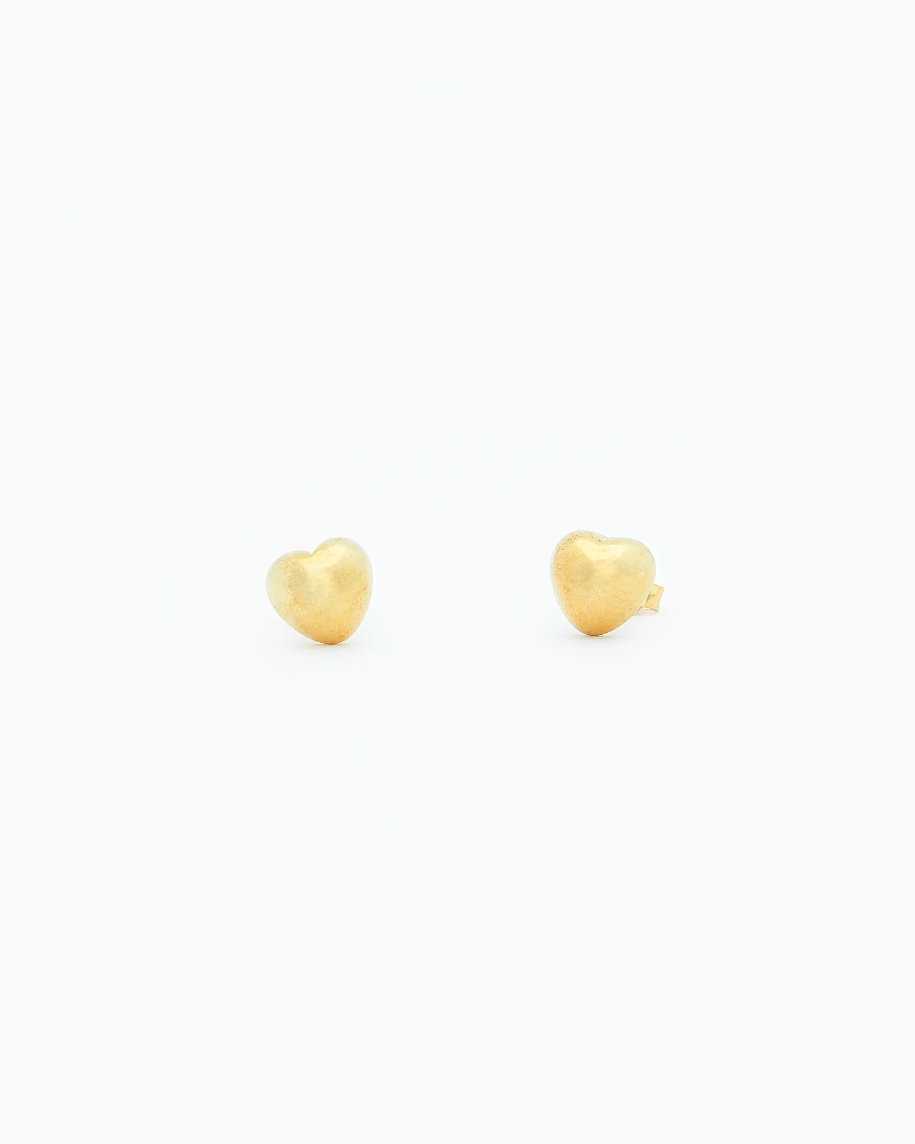 Gold heart-shaped earrings on a white background