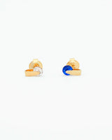 Gold earrings with blue gemstones on a white background