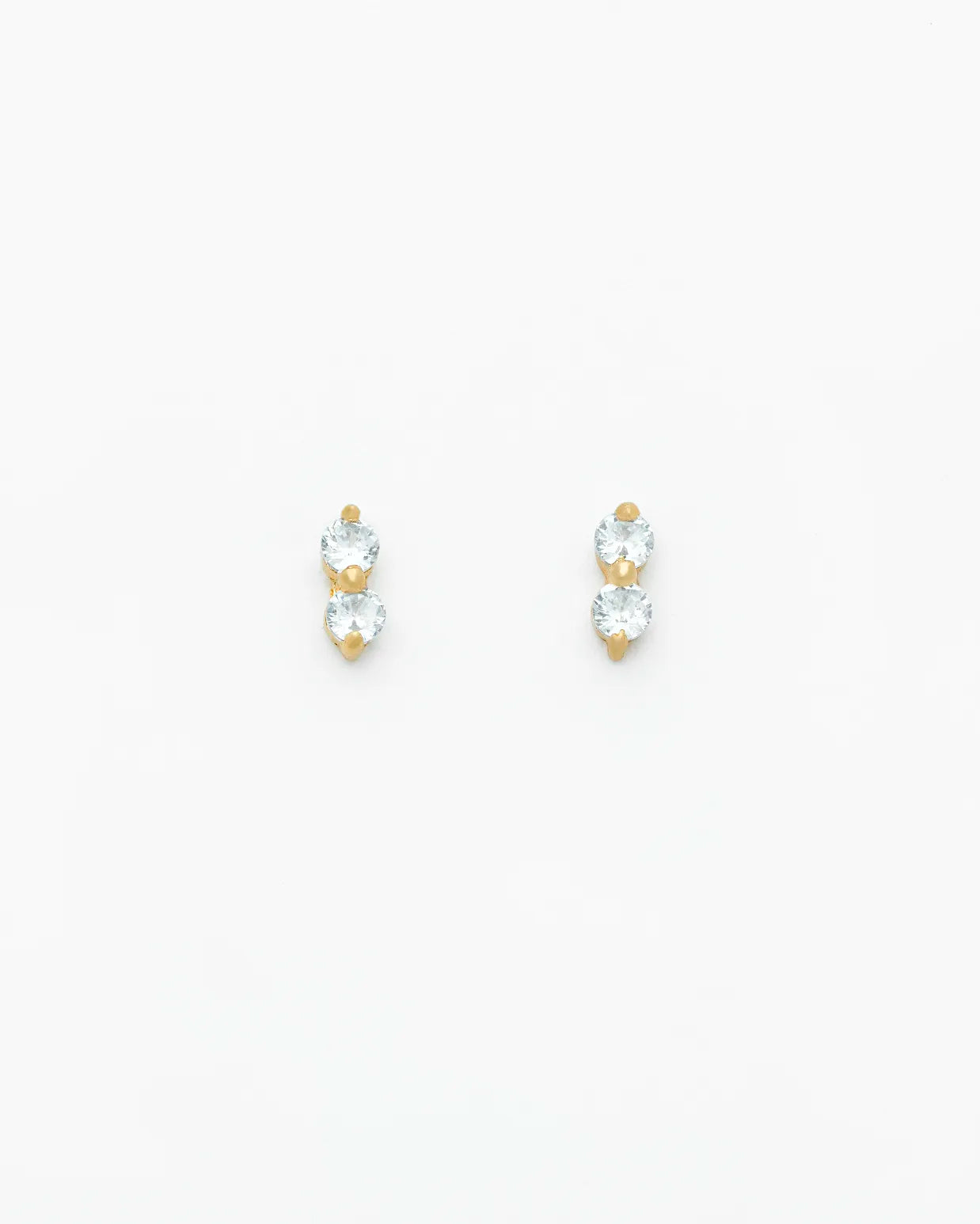 Pair of gold and clear crystal stud earrings on a white background
