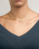 Gold necklace snake chocker with a star pendant worn by a girl with a teal shirt